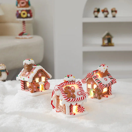 Decorative gingerbread house lights on a snowy surface with a blurred background
