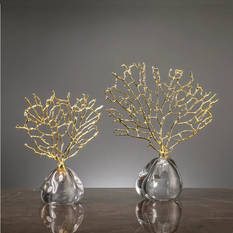 Two decorative pieces with gold coral-like structures on clear bases against a gray background