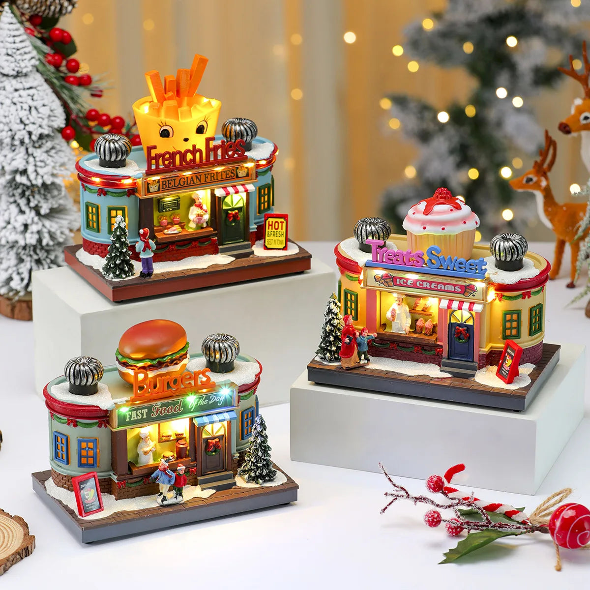 Set of miniature model shops including a fast food restaurant and ice cream shop on a decorative surface with Christmas decorations.
