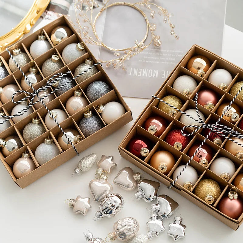 Decorative Christmas ornaments in open boxes on a white surface with a blurred background.