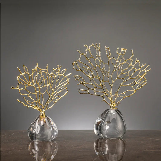 Two decorative pieces with gold coral-like structures on clear bases against a gray background