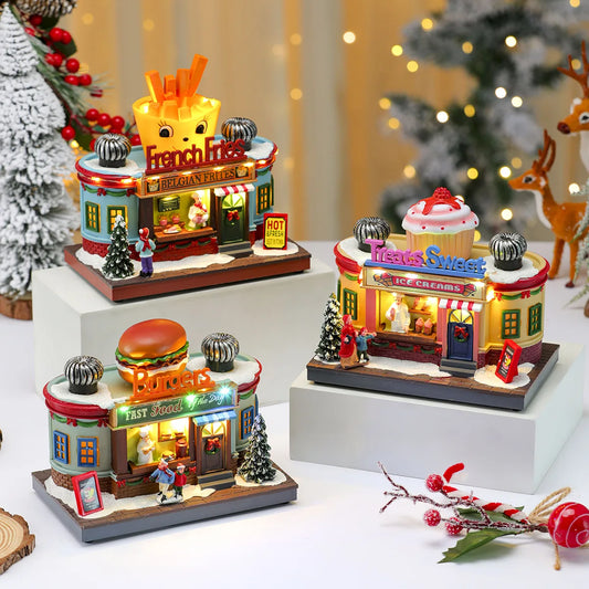 Set of miniature model shops including a fast food restaurant and ice cream shop on a decorative surface with Christmas decorations.