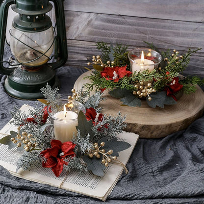 Decorative setup with candles, greenery, and a lantern on a wooden surface.