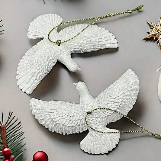 White dove-shaped ornaments on a gray surface with Christmas decorations.