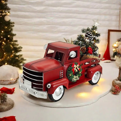Decorative red truck with Christmas decorations on a white surface with a festive background.