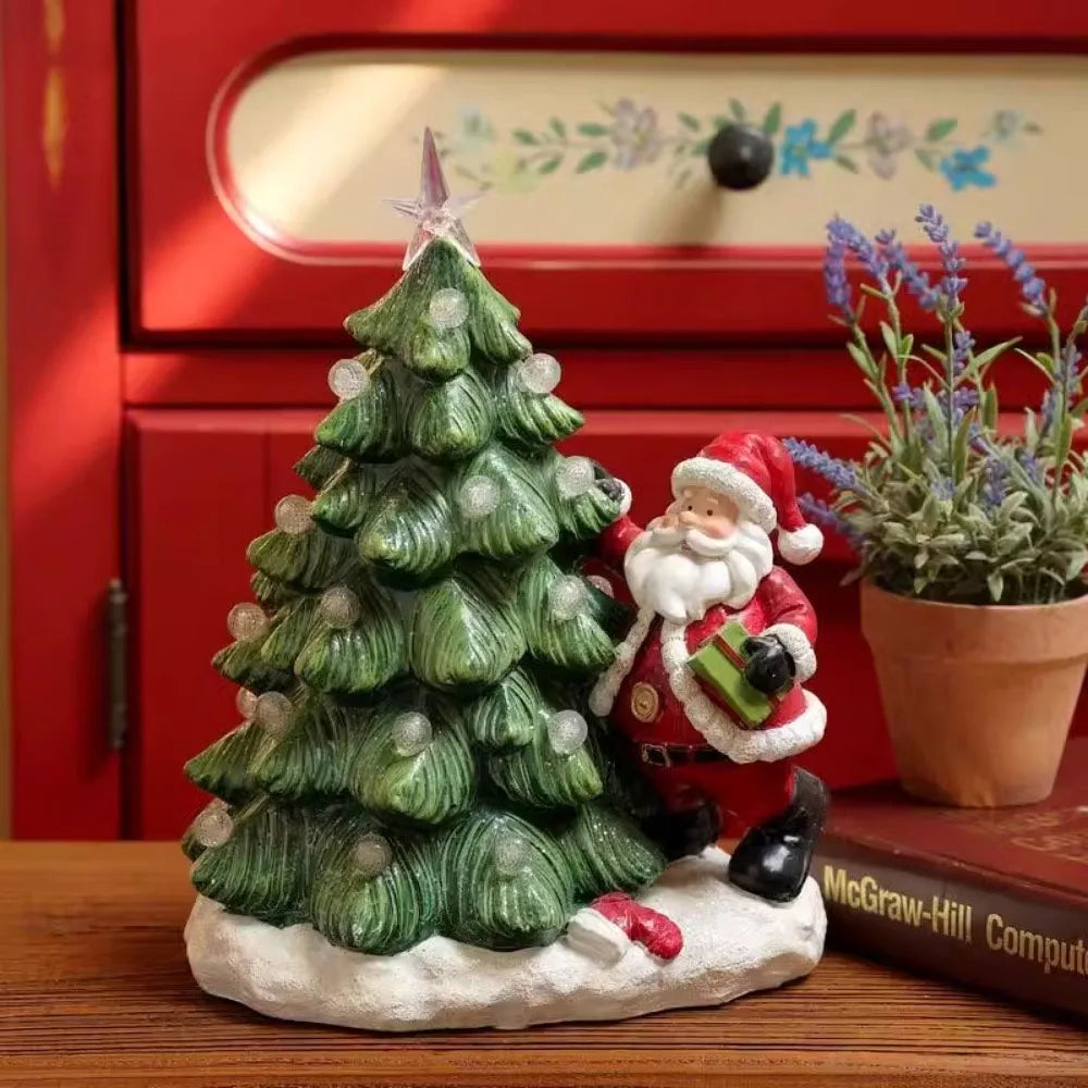 Decorative Christmas scene with a tree and Santa Claus figure on a wooden surface.