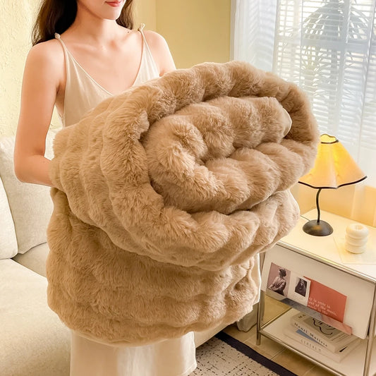 Person holding a soft faux-fur beige blanket in a warm, cosy living room with soft lighting